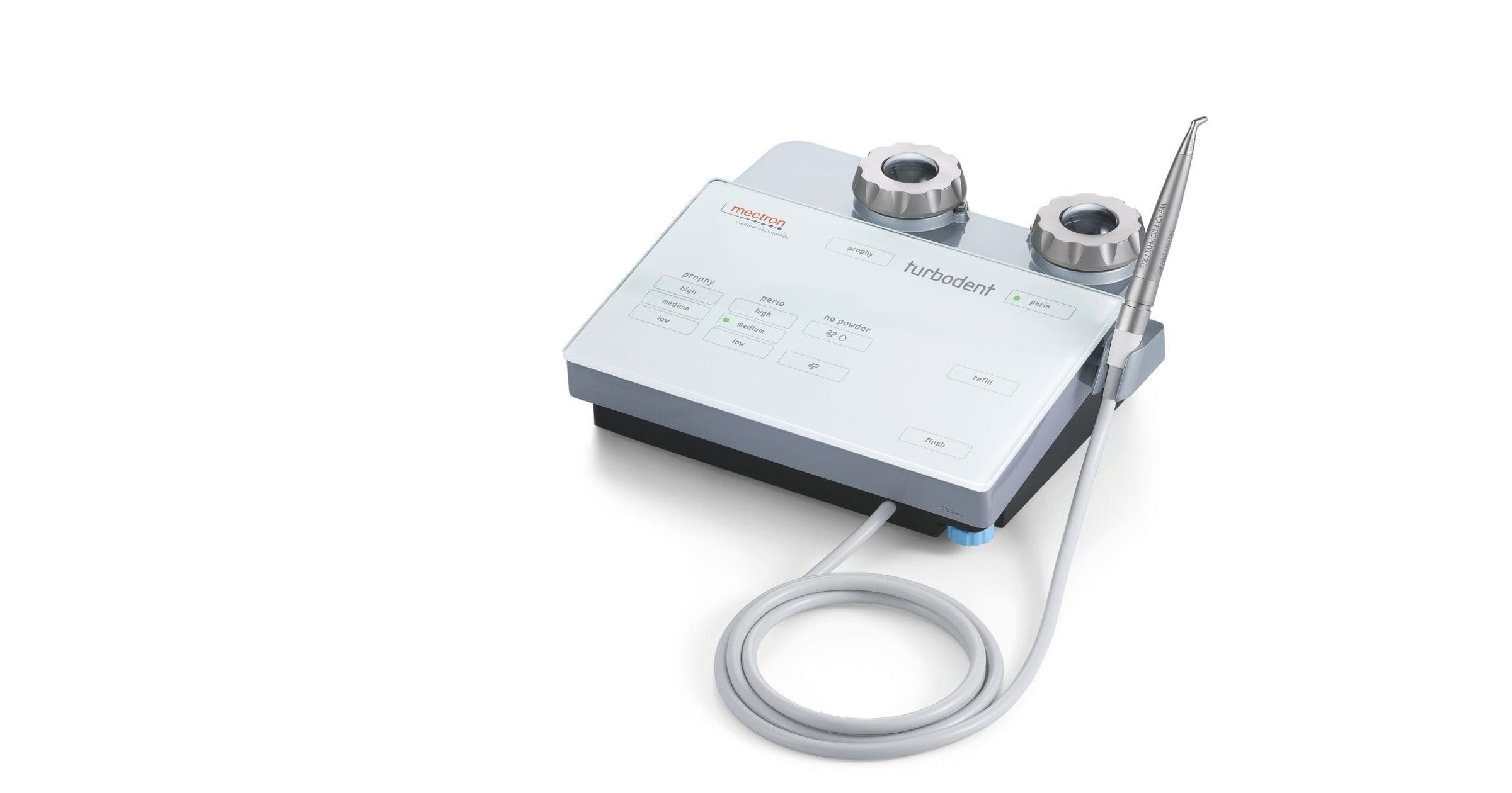 Produktfoto des mectron Turbodent touch: Pulverstrahlgerät mit Touchscreen-Bedienfeld, zwei Pulverkammern und angeschlossenem Handstück.