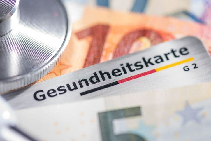 Health card with banknotes and stethoscope