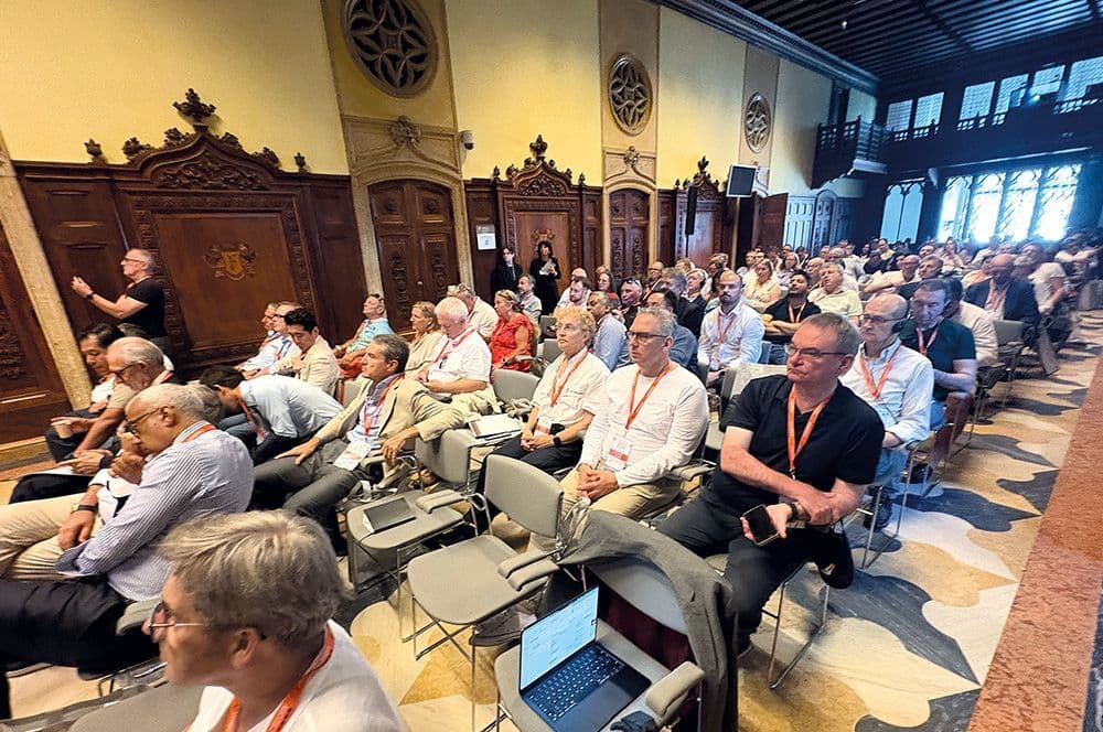 Publikum in historischem Saal mit holzvertäfelten Wänden bei einem Vortrag